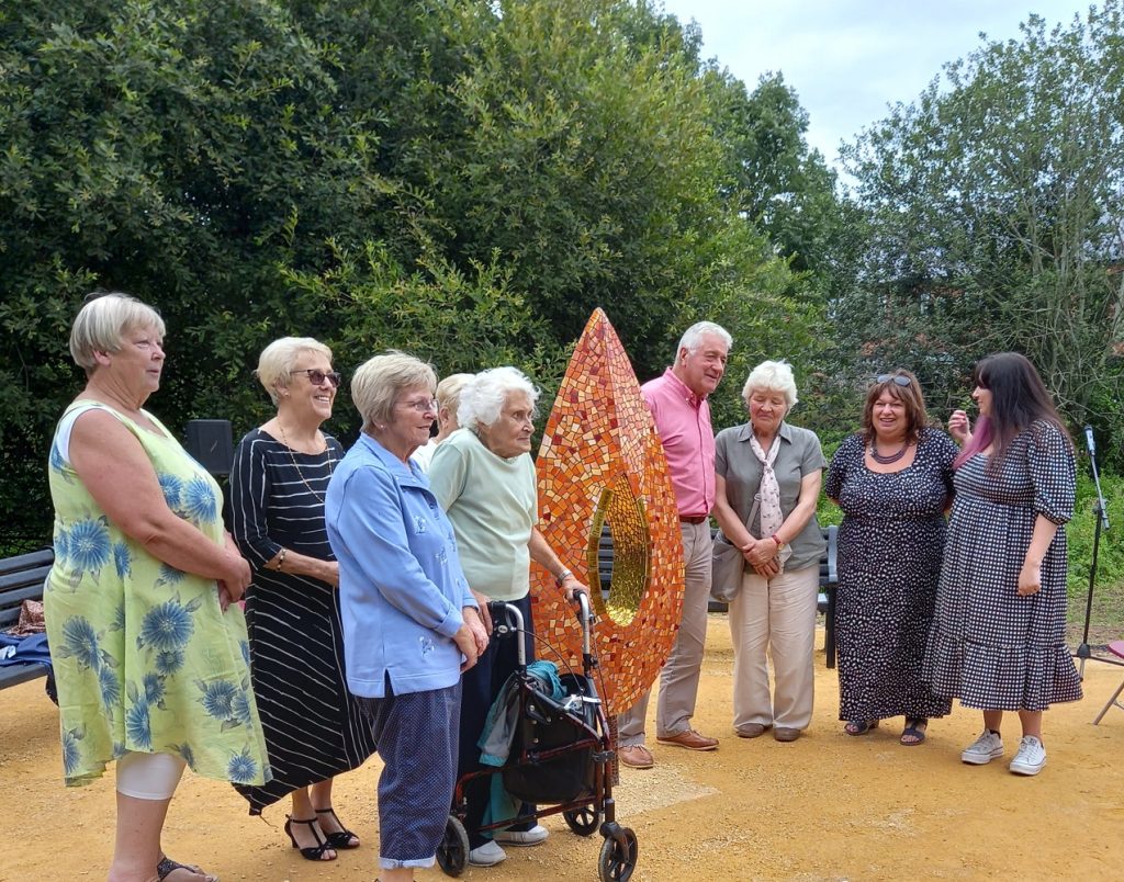Relatives of those affected by the bombing gather around the Meco Memorial at its unveiling